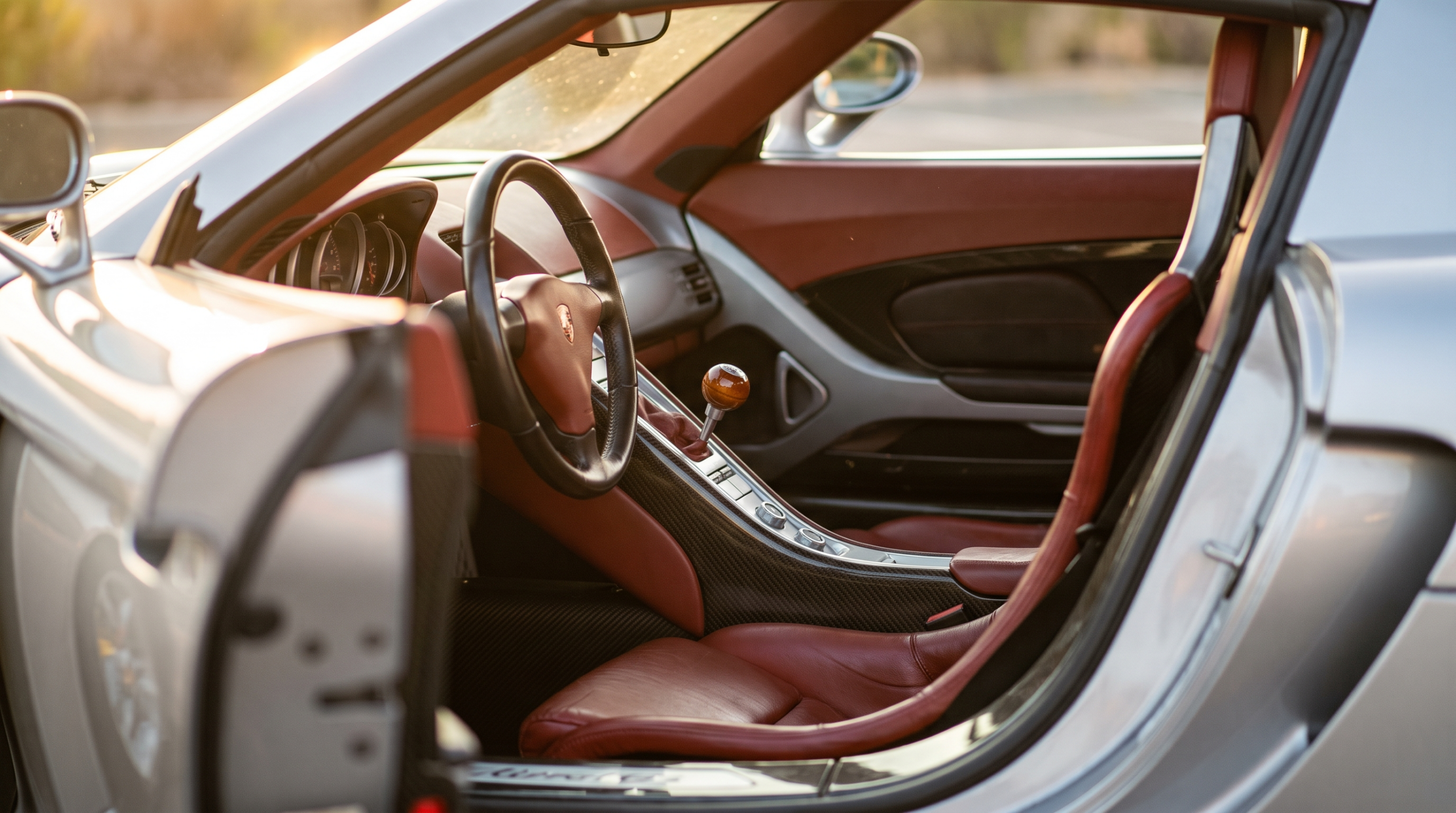Exotic car values and analog appeal: a carbon-fiber console and manual gear lever in a mid-2000s supercar