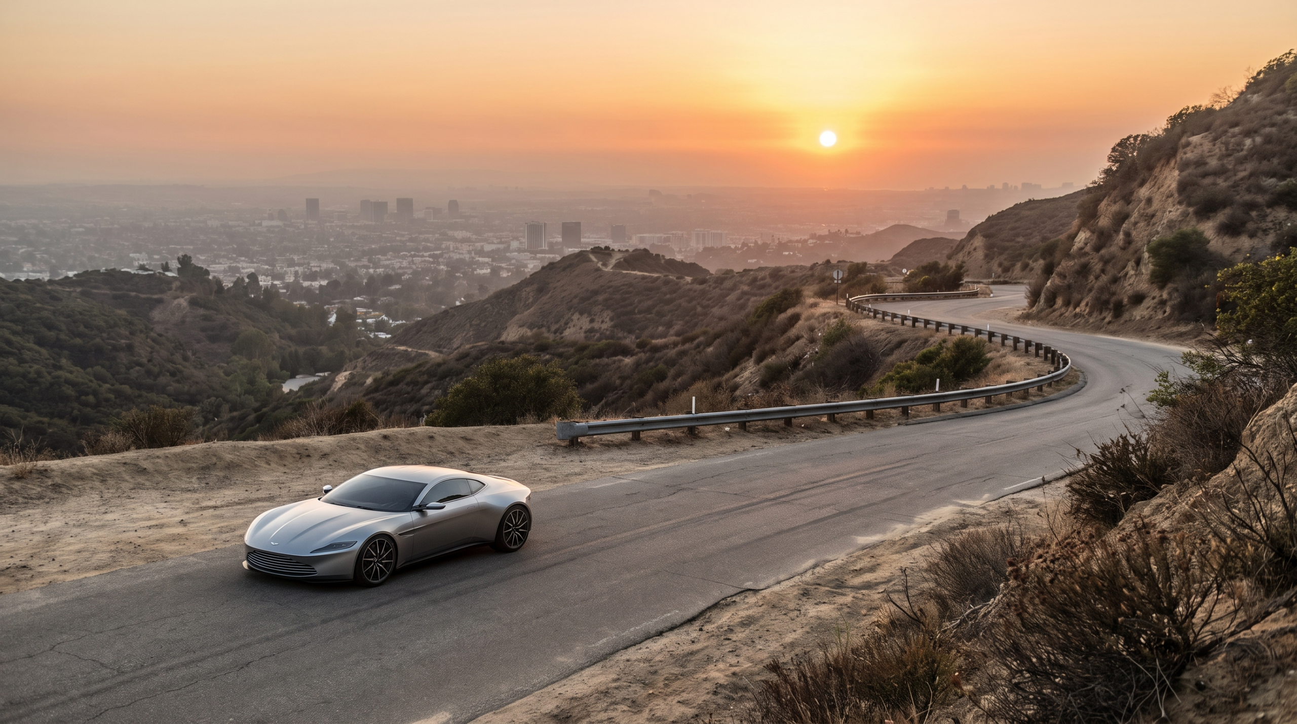 Silver supercar on a canyon road above a city at golden hour