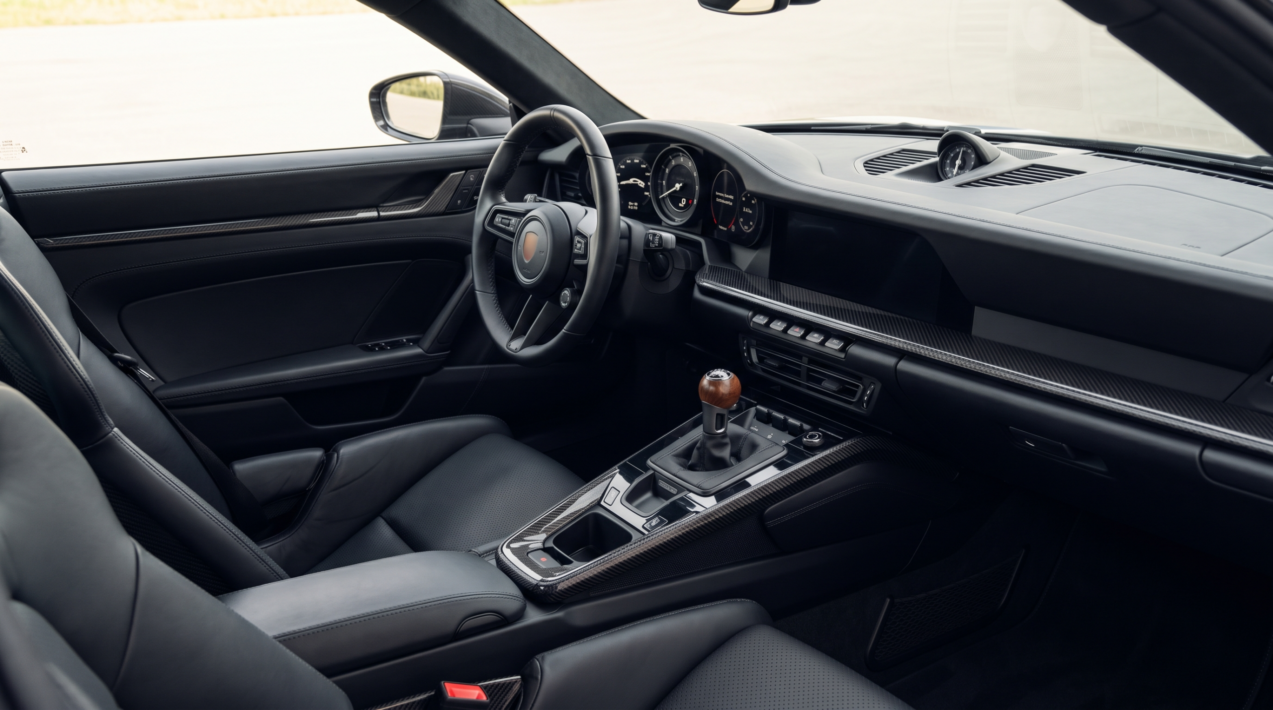 Modern sports car interior with a short manual transmission lever and walnut shift knob