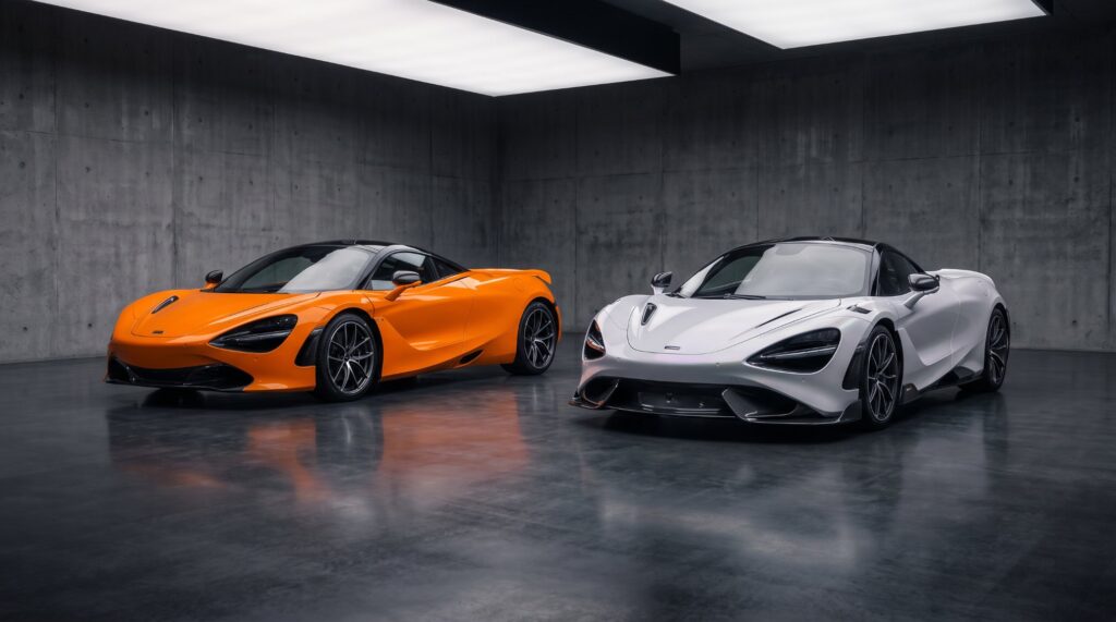 Illustration of an orange McLaren 720S coupe and a white McLaren 750S coupe parked side by side in a concrete gallery