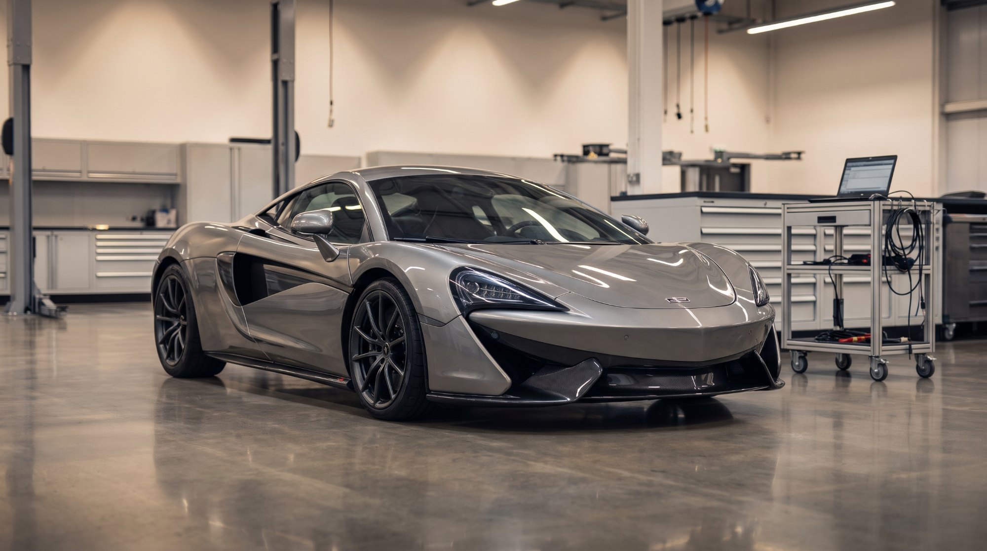 Grey McLaren 570S coupe parked in a supercar specialist workshop (AI-generated illustration)